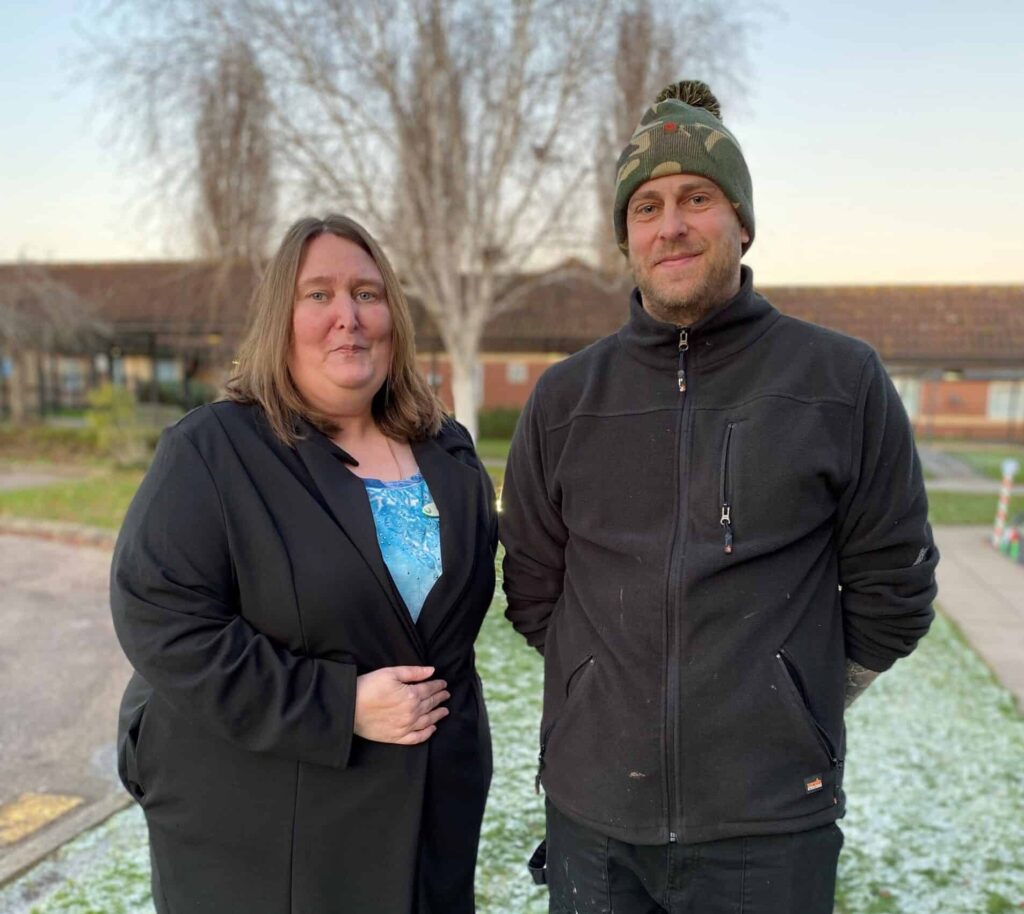 Man and woman stand on snowy backdrop at Ipswich Care Home after award presentation
