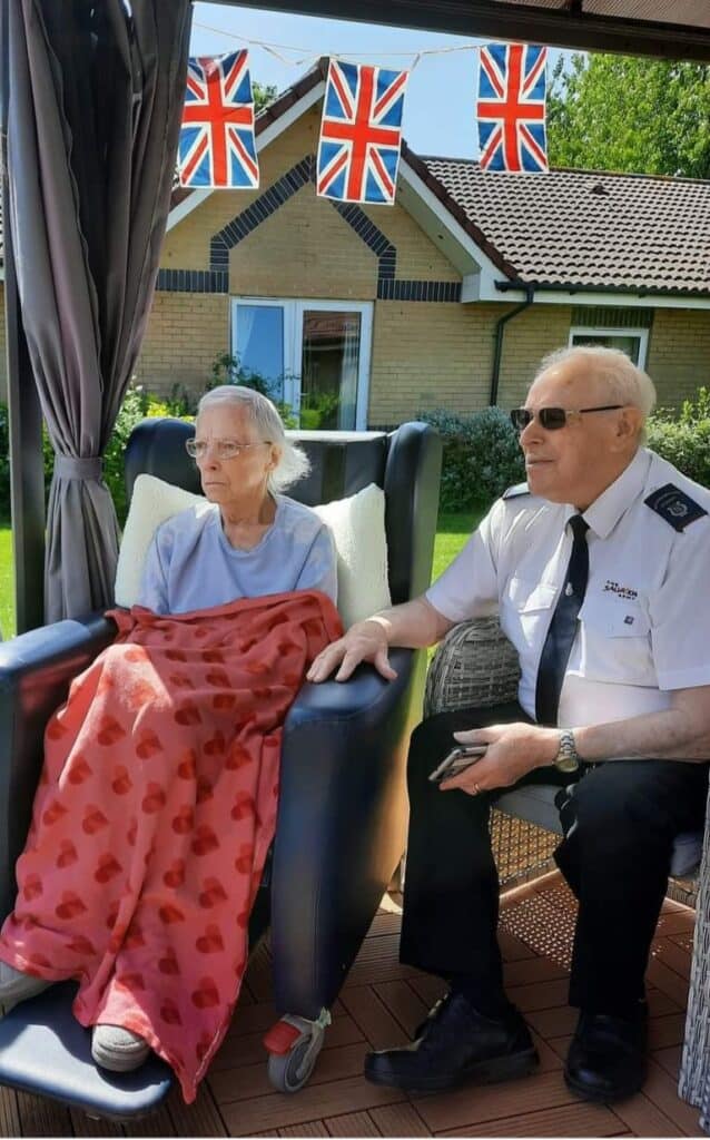 Couple sit in garden at care home