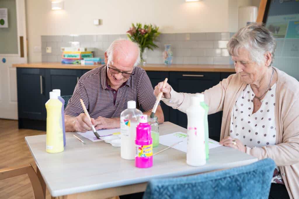 Couple enjoying painting session during dementia cafe