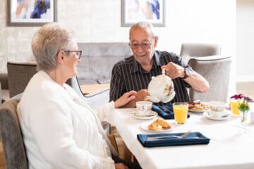 Couple sit at table enjoying breakfast